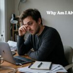 Exhausted young man feeling tired and fatigued while sitting at a desk in the morning
